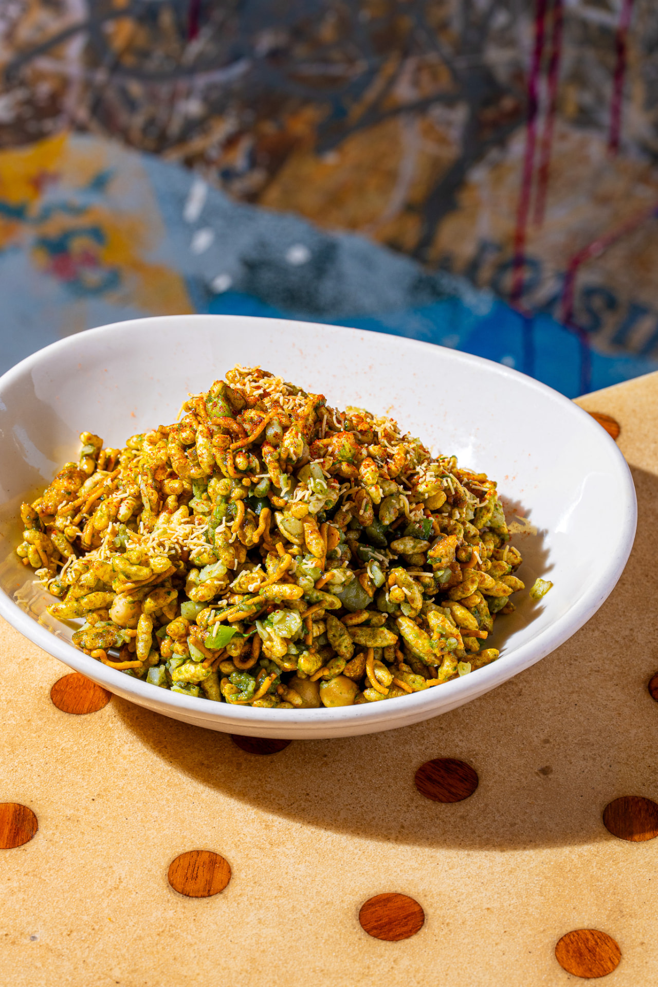 Bhel Puri in the bowl, with mural behind