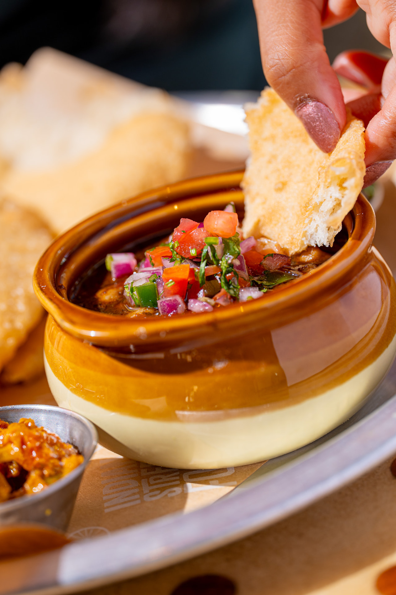 Chole bhature, dipping bhatura into the chana