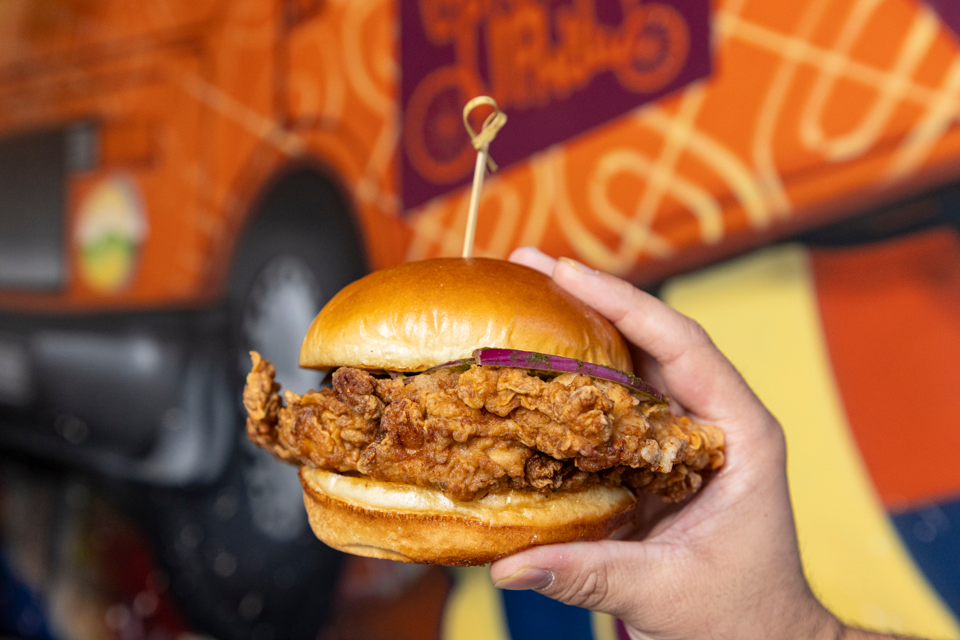 Fried chicken sandwich held up in front of the truck