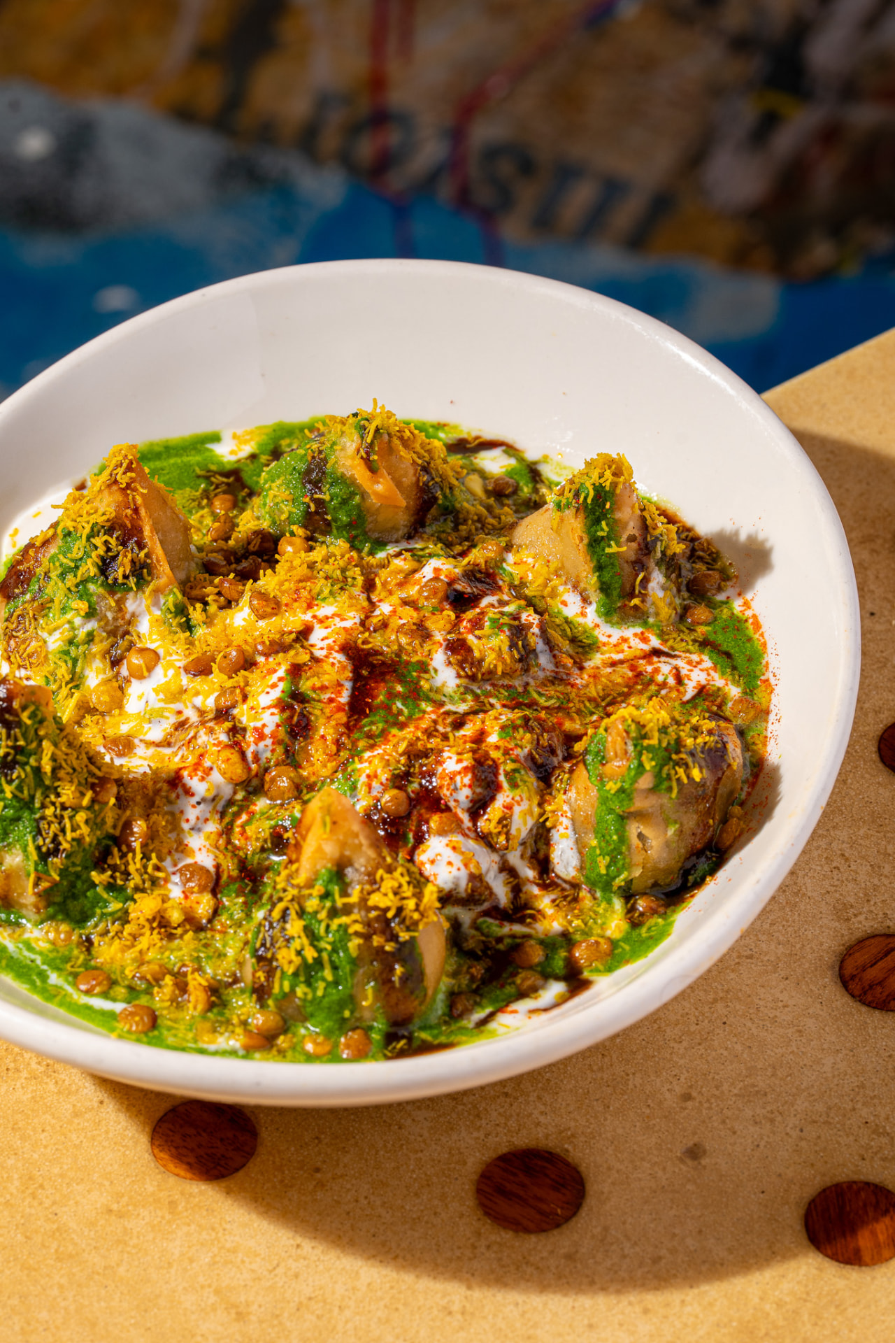 Samosa Chaat bowl, overhead with chutneys and sev