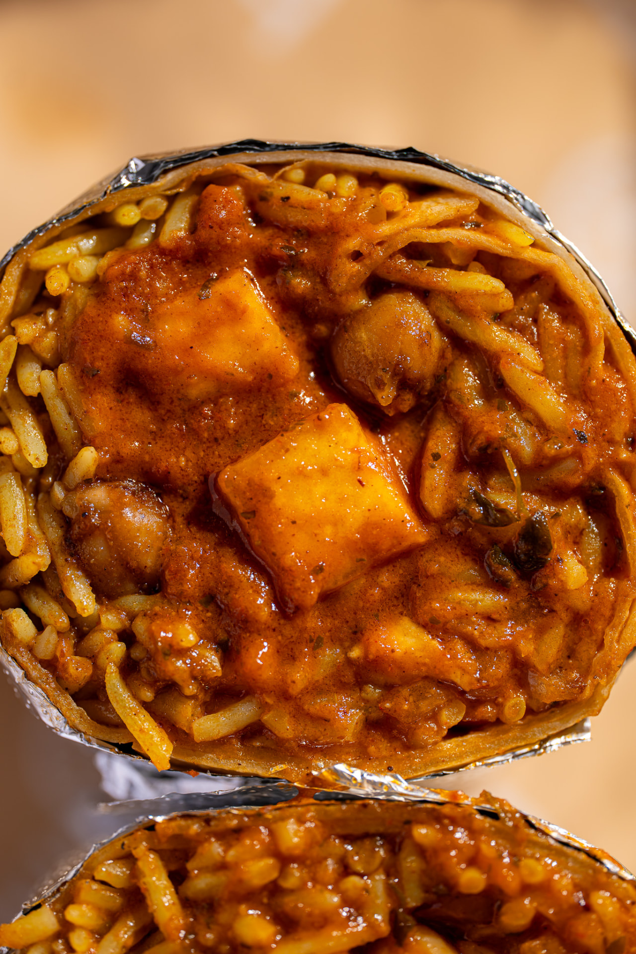 Paneer tikka masala burrito with chana, macro on the cut face