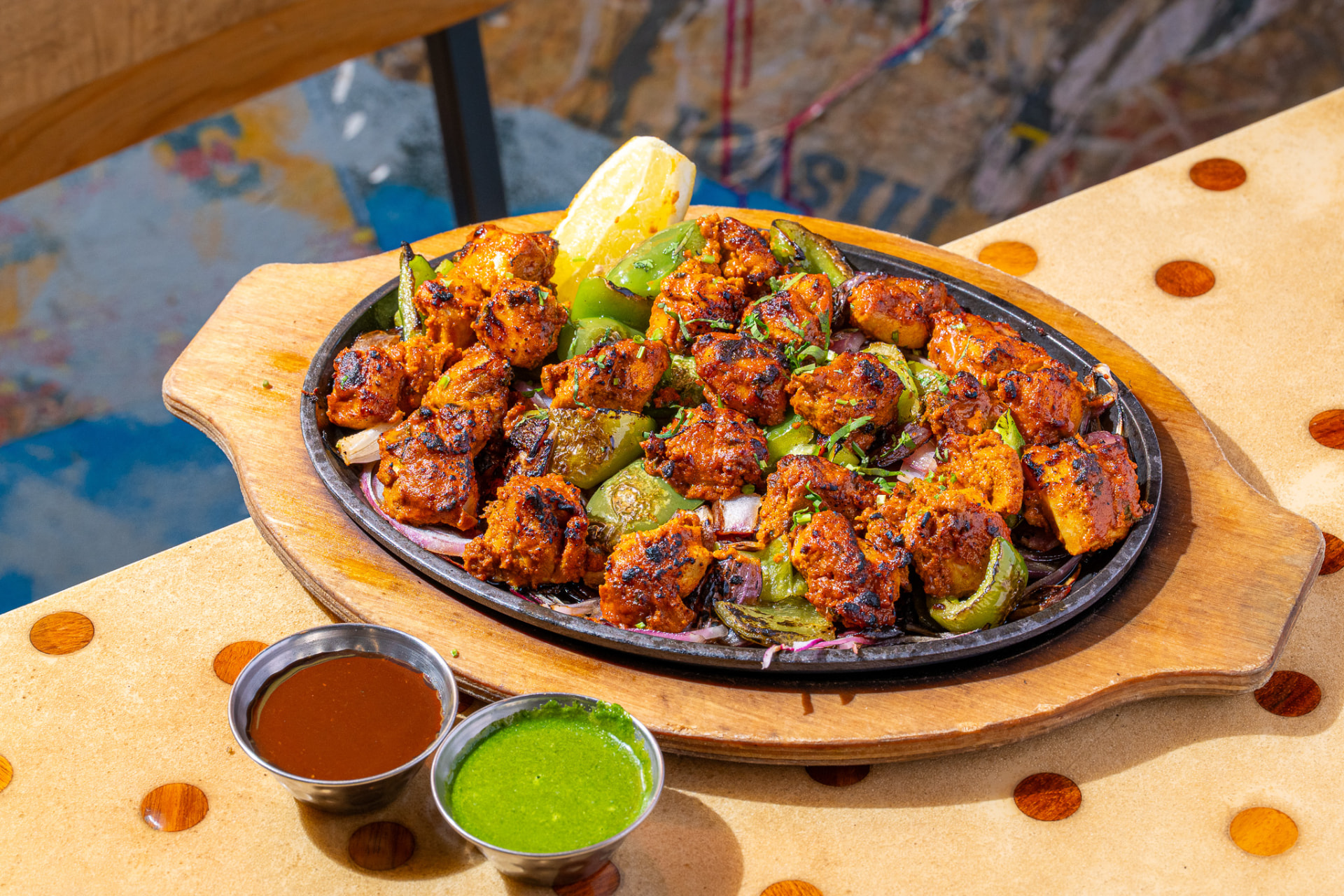 Sizzlin Kabab on the sizzler, angled with chutneys