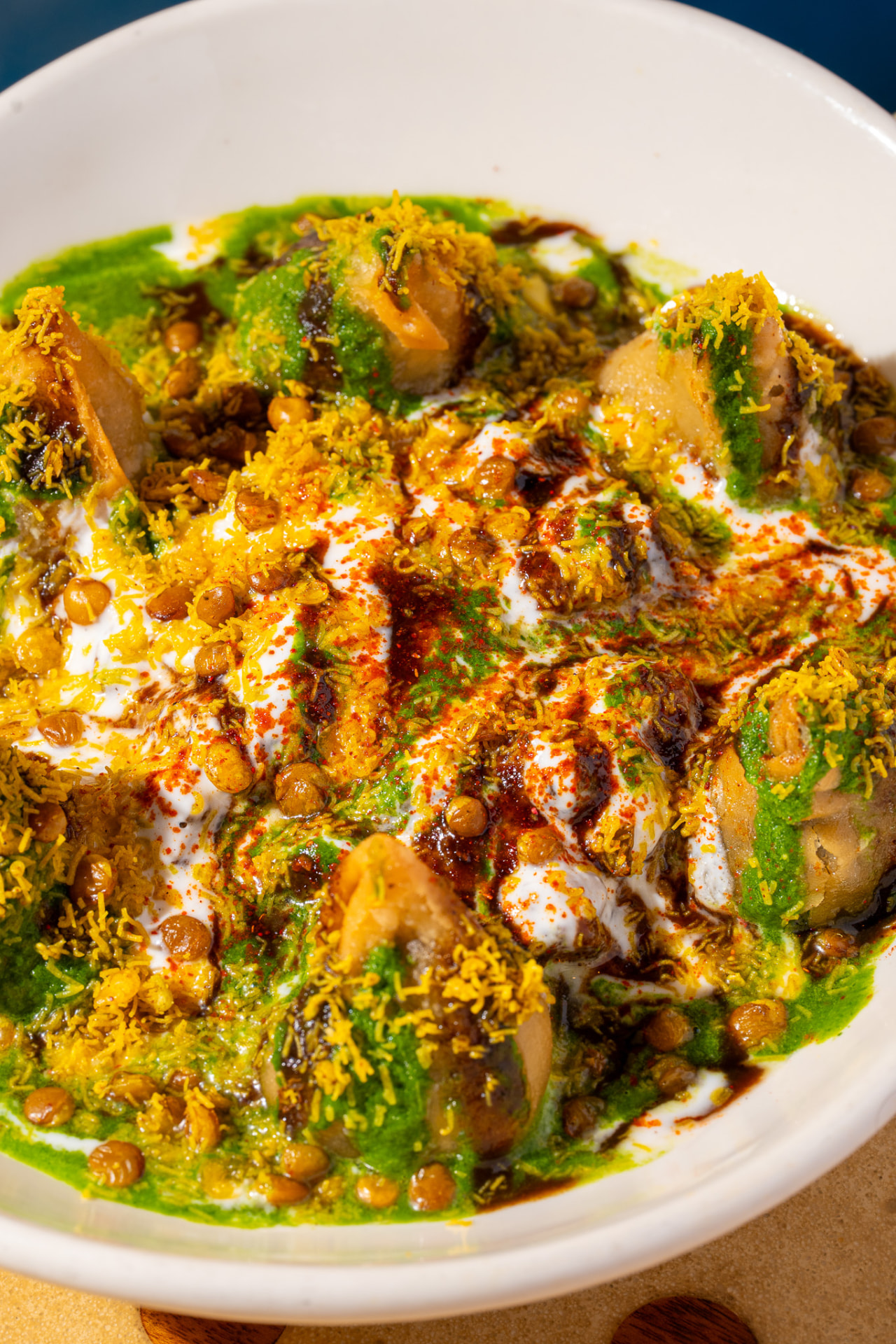 Samosa Chaat, close up on yogurt, chickpeas and sev