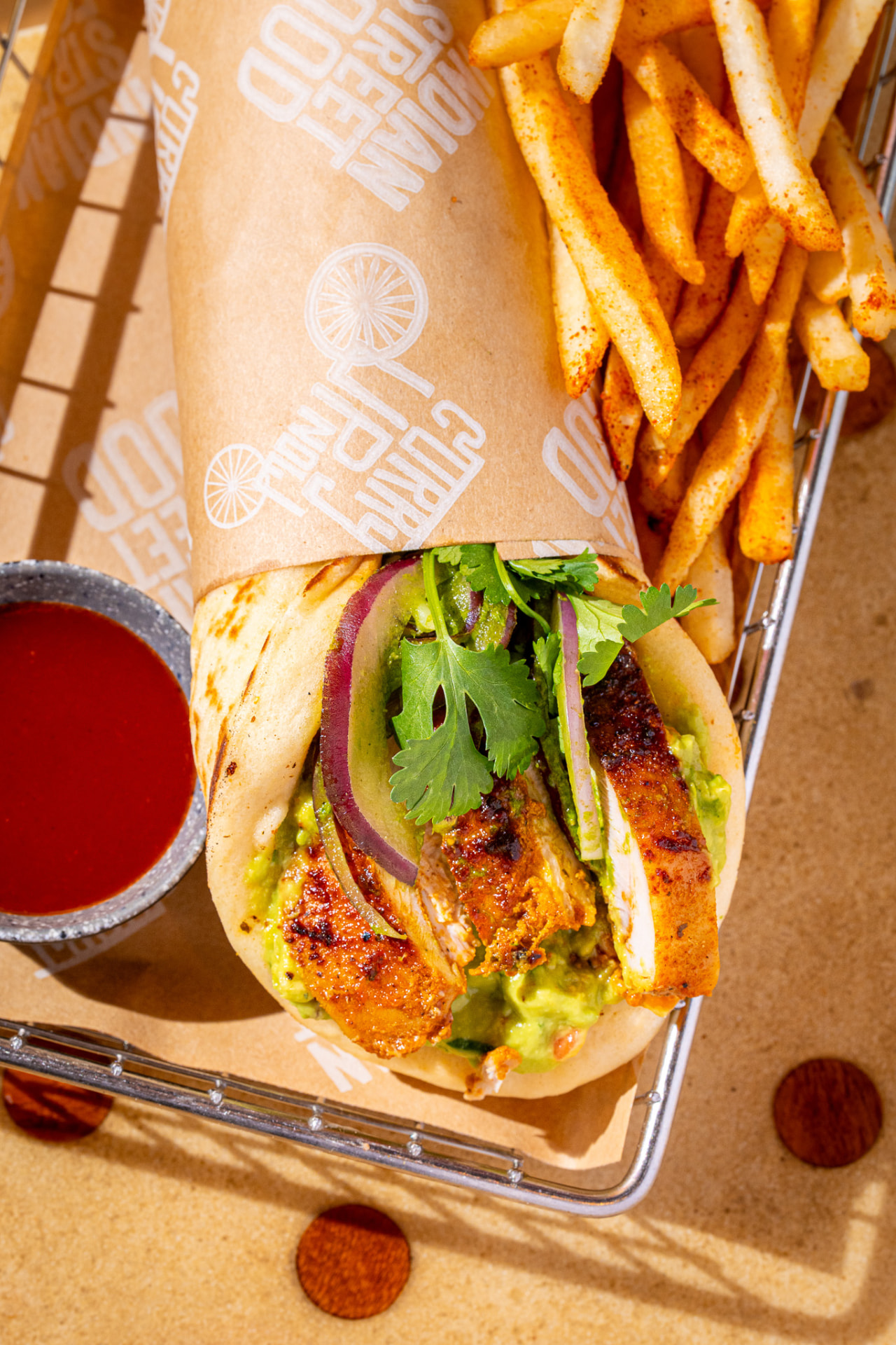El Jefe in the basket with peri-peri fries and hot sauce, overhead