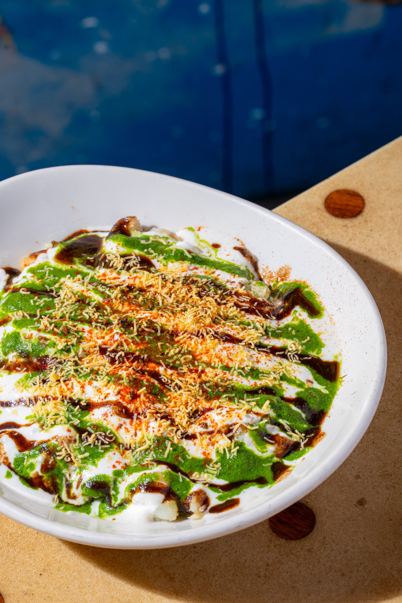 Kachori Chaat bowl, yogurt, chutneys and sev, angled