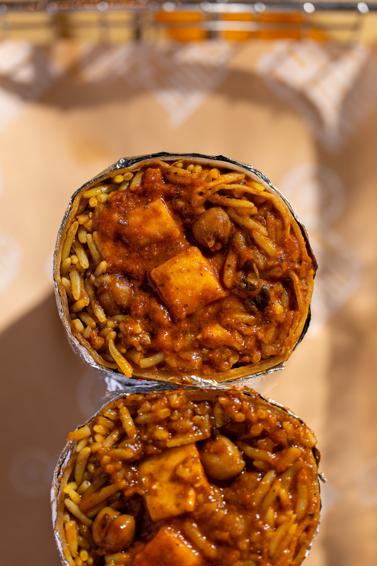 Paneer tikka masala burrito with chana, both halves overhead