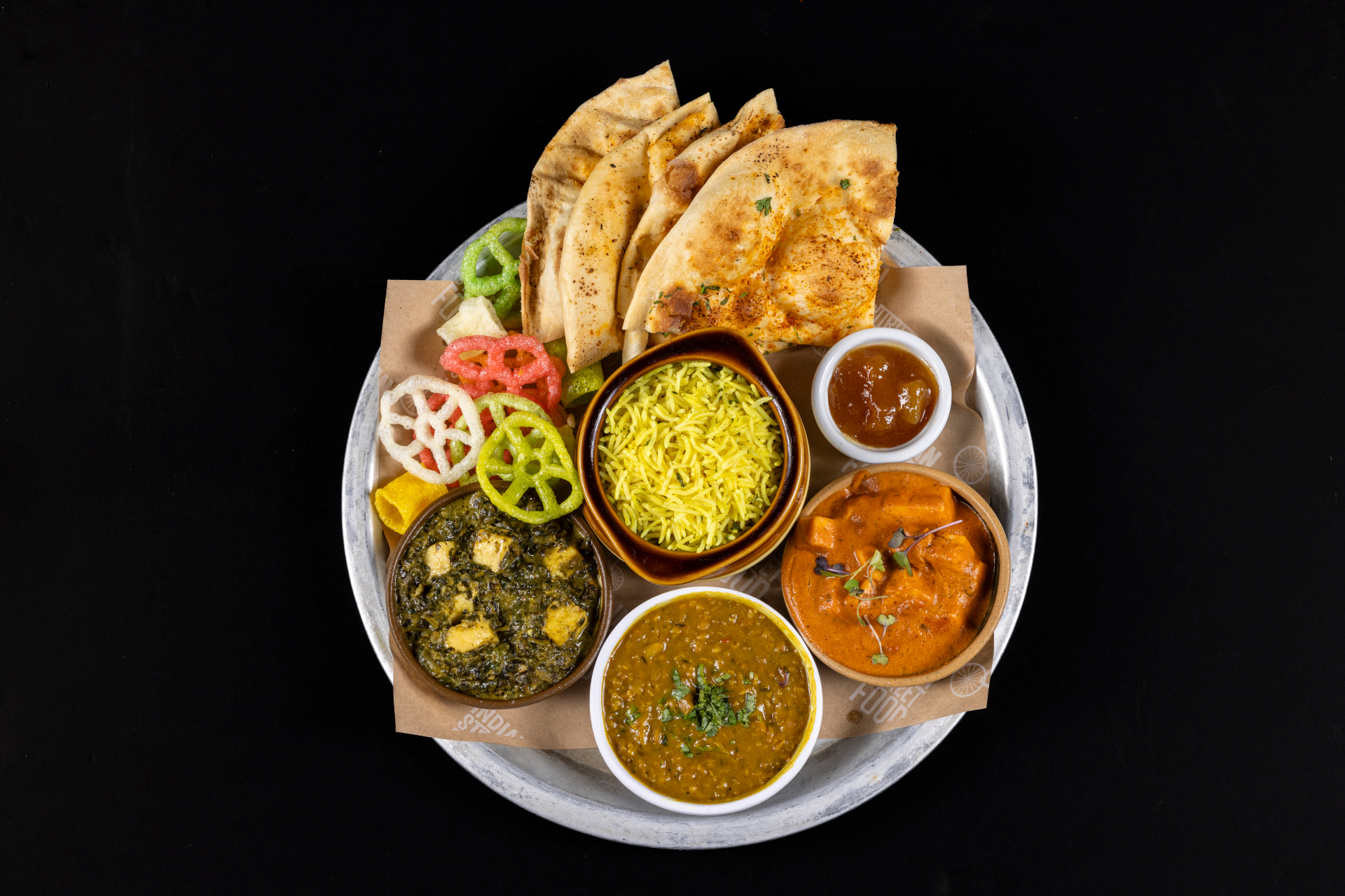Thali overhead: saag paneer, tikka masala, dal, turmeric rice, naan, chutney