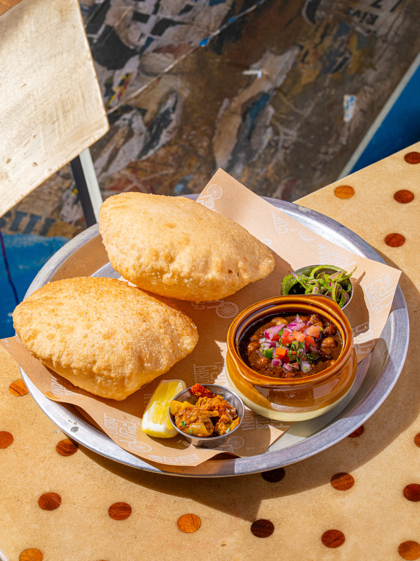 Chole bhature platter with chana, pickle, pepper onion salad and lemon